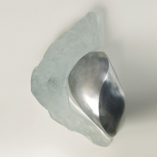 Elegant cremation urn Atemporal | Etternal: a polished metal inner cup encircled by a frosted, irregular glass-like shell.