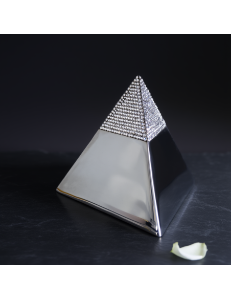 Crystal Pyramid Keepsake with Swarovski-studded apex, metallic silver base, on a dark surface; a white petal lies nearby.
